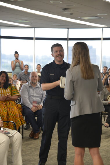 Parker Police Officer Jonathan Warn receives his certificate of citizenship at the US Citizenship and Immigration Services in Centennial during a ceremony.